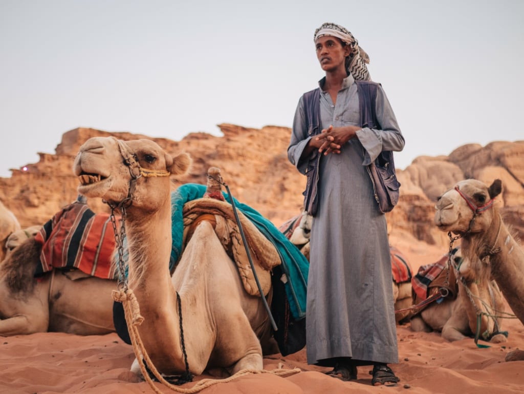 A Jordanian standing with his camels in Wadi Rum, Jordan