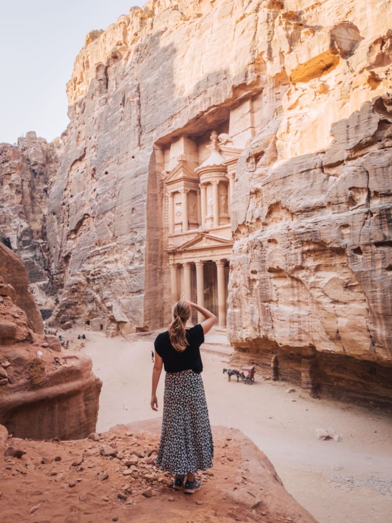 Alexandra Hayward (@findingalexx) standing in front of the Khazneh in the ancient town of Petra in Jordan
