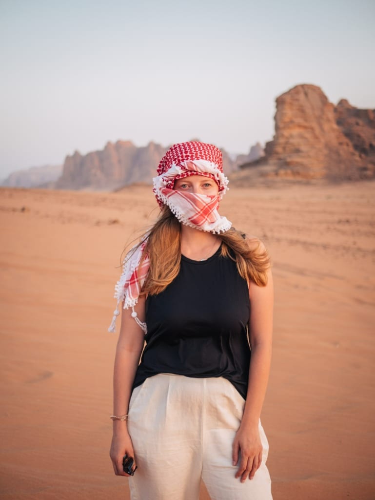 Alexandra Hayward (@findingalexx) standing in the Wadi Rum with an Arab scarf