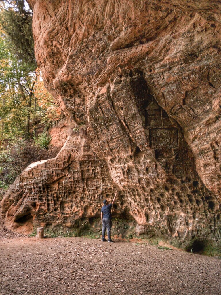 Mohamed Nawaz holding up his hand towards Gutmanis Caves in Sigulda, Latvia