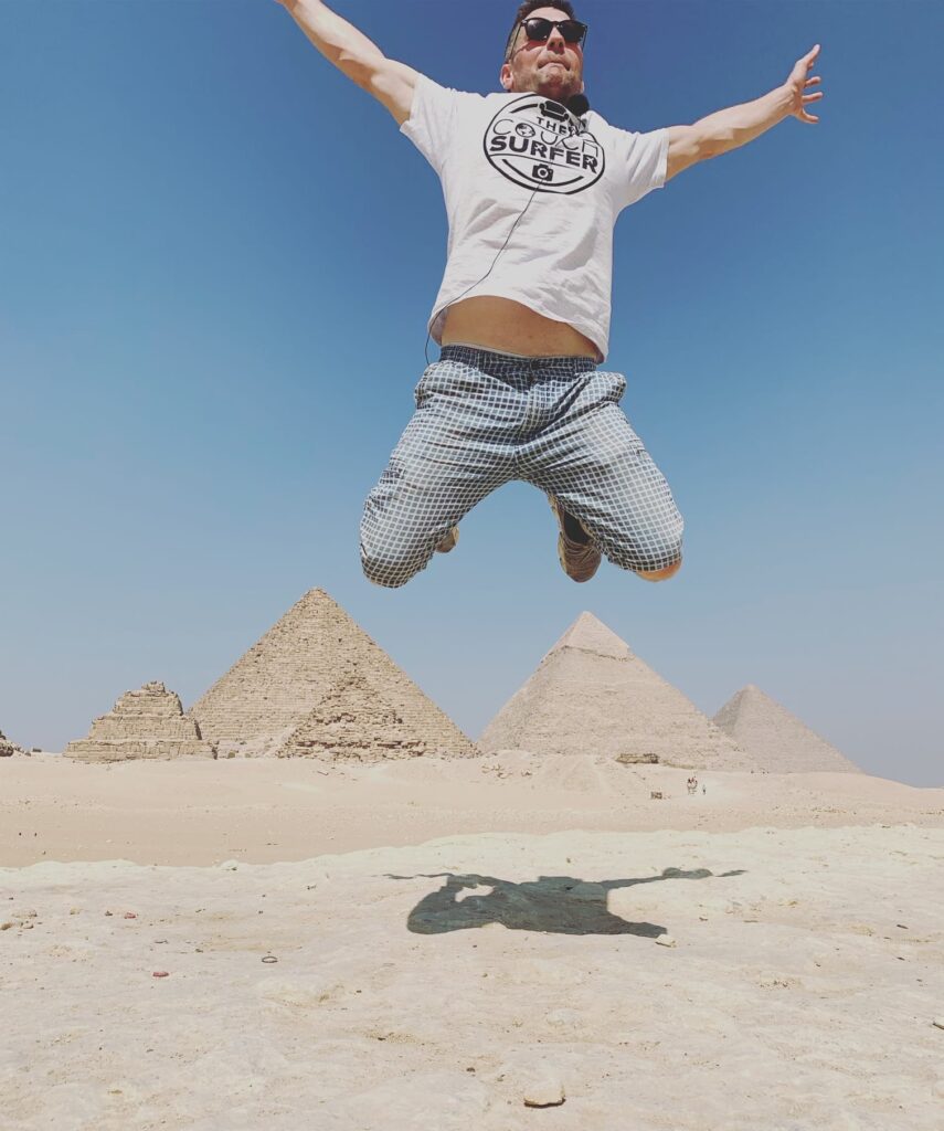 Eivind jumping with the Pyramids behind him. Egypt Couchsurfing.