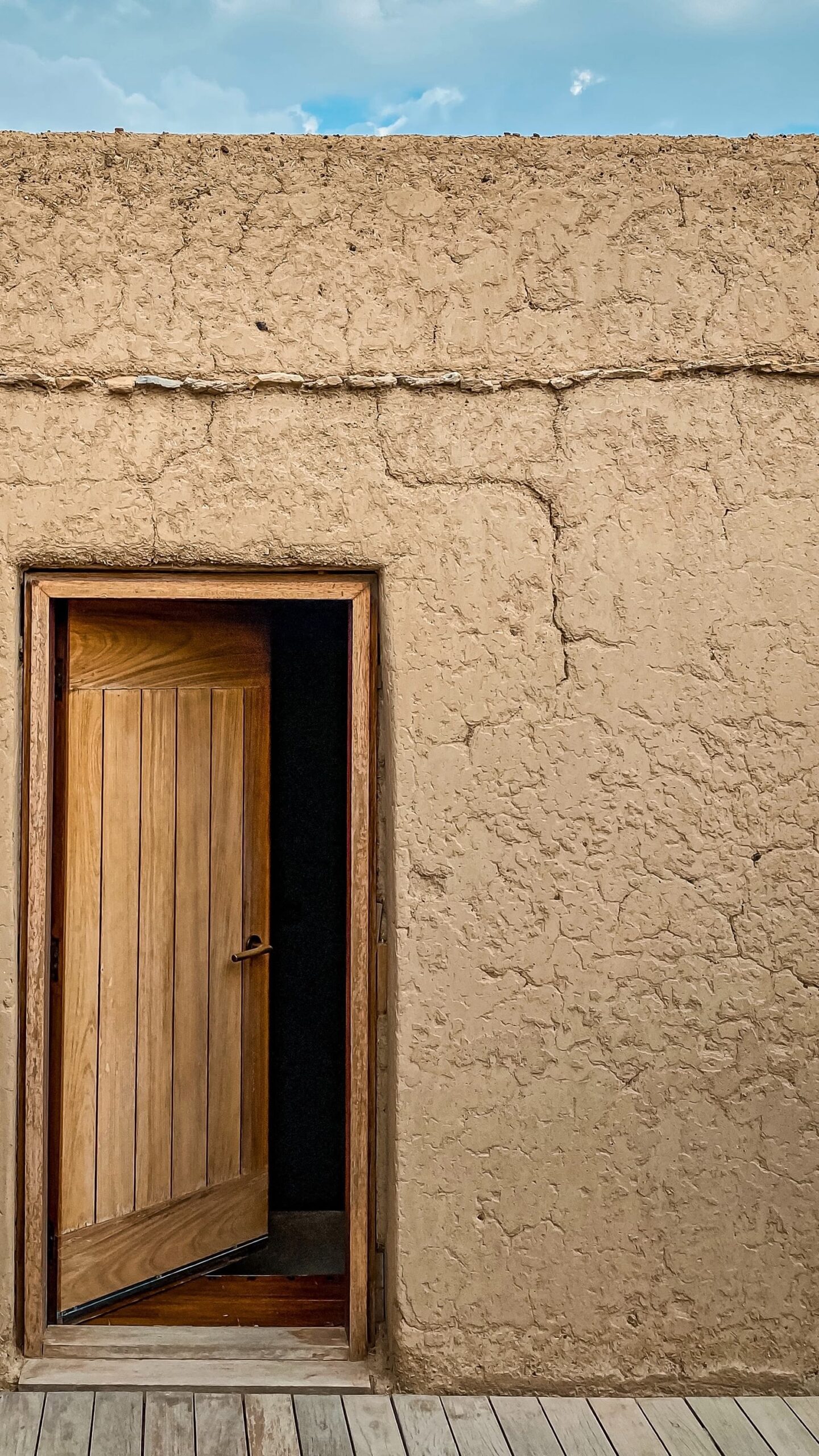 A door in a an old housing with wall having slight fringes forming